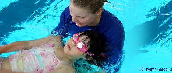 тренер учит девочку плавать на спине